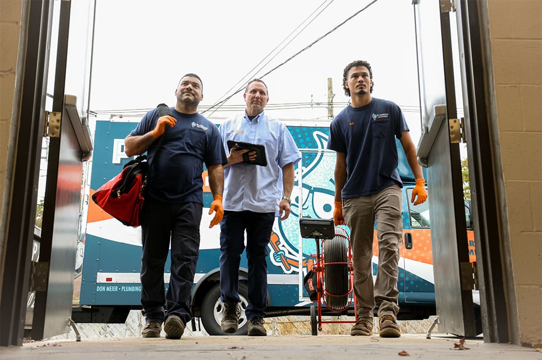 Plumbing Solutions Inc., technicians and owner walking up to job site in front of a company truck